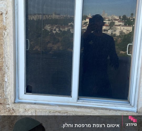 ילד ליד חלון עם השתקפות נוף